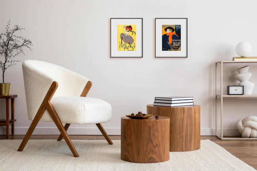 Two epaper frames displaying vintage poster art on a neutral living room wall without cables