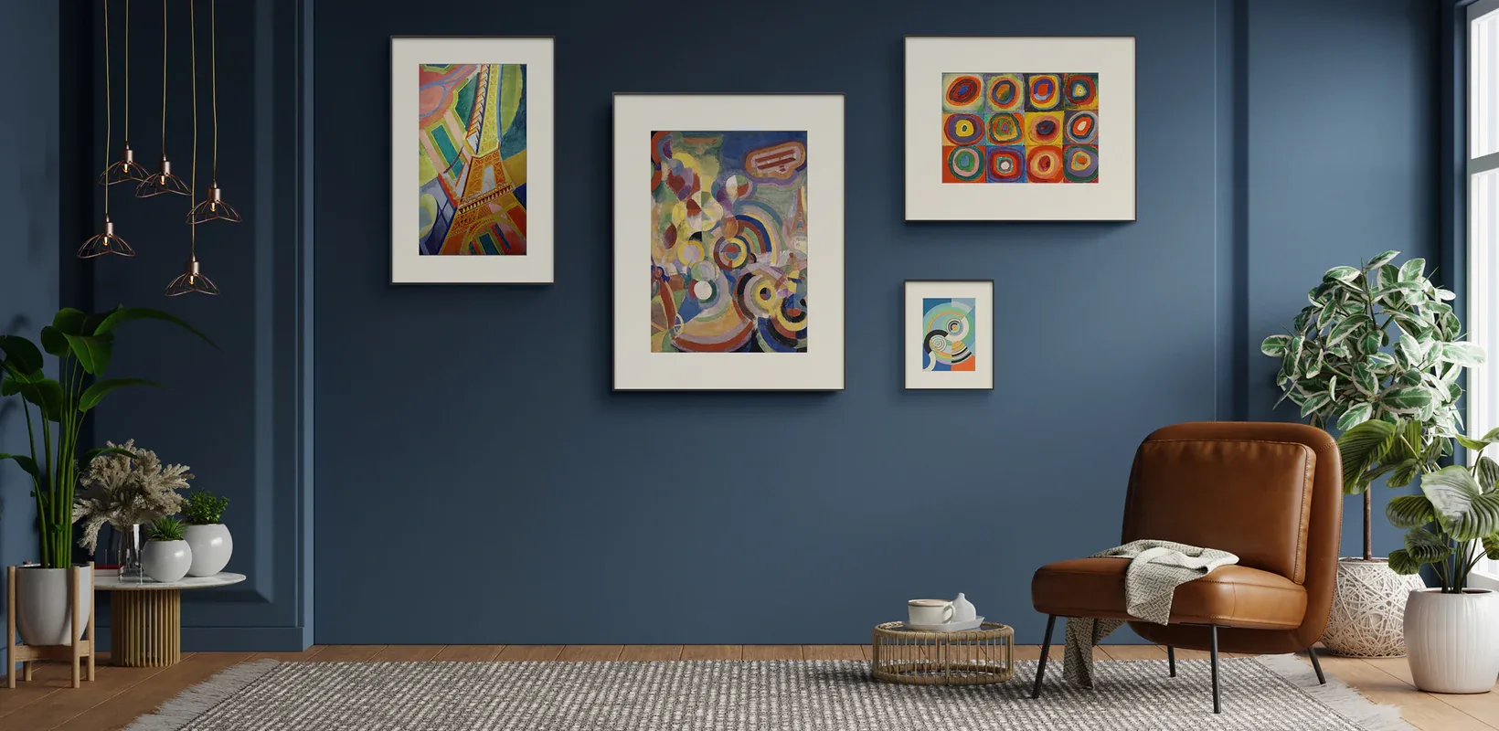 A coordinated gallery wall of colour artwork in a blue interior